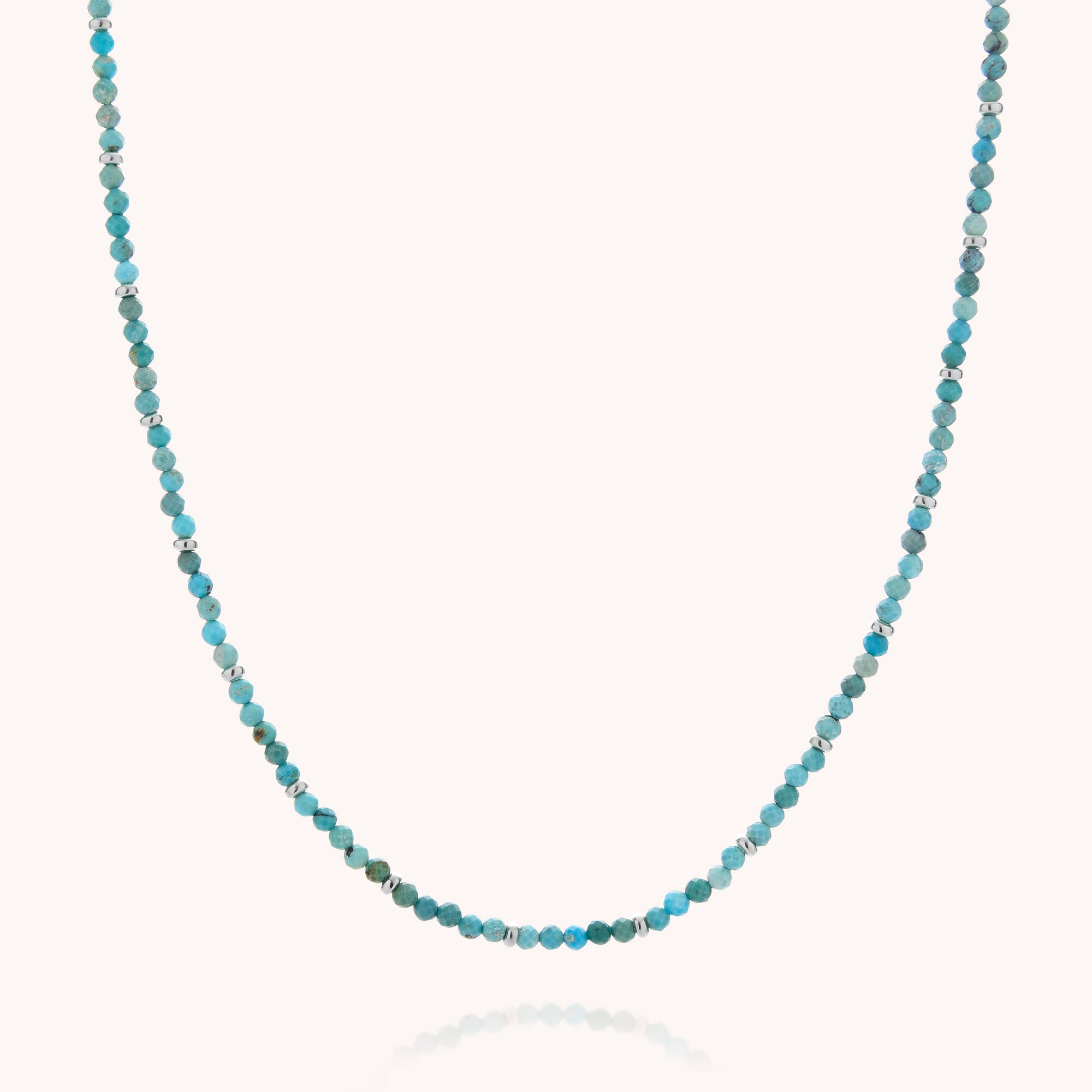 The Turquoise December Birthstone Orbit Necklace is a delicate handcrafted jewelry piece, featuring small, round blue and turquoise beads with occasional silver accents, beautifully displayed on a white background.