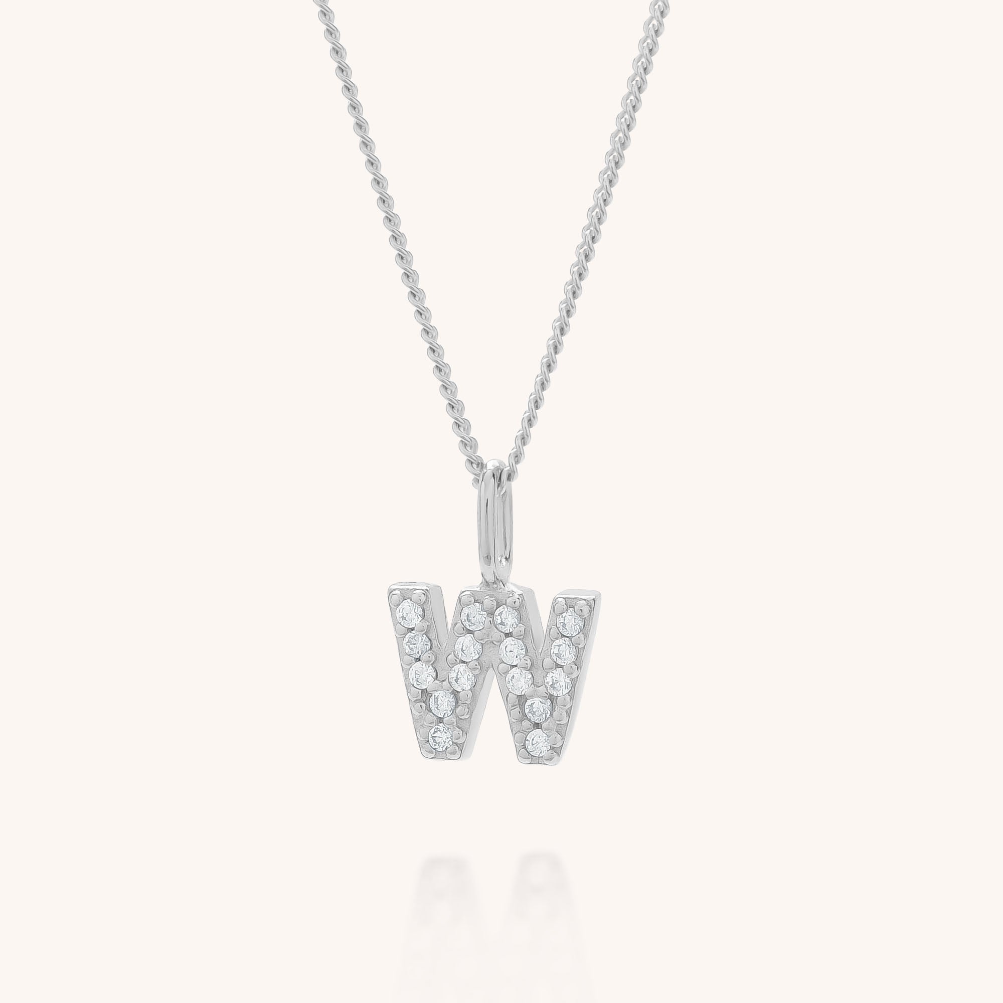 The Initial Sparkle Necklace is a silver personalized piece with a W-shaped pendant adorned with sparkling cubic zirconia, set against a plain light background.