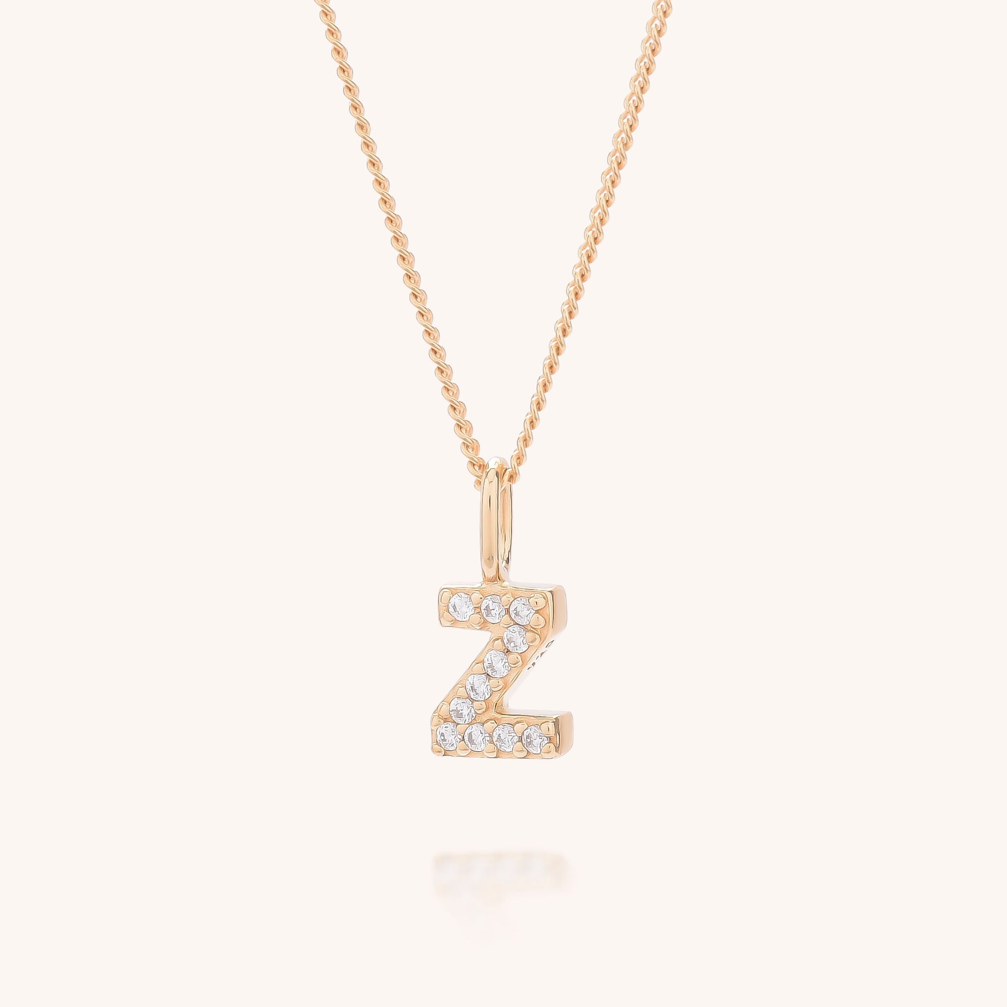 The Initial Sparkle Necklace showcases a gold chain with a Z-shaped cubic zirconia pendant, creating a striking, personalised accessory that stands out against any light background.