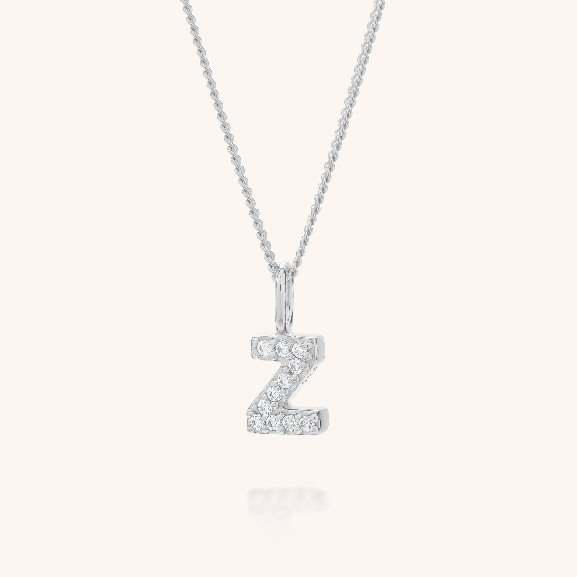 The Initial Sparkle Necklace features a silver letter Z pendant adorned with sparkling cubic zirconia stones, suspended on a delicate chain against a light background.
