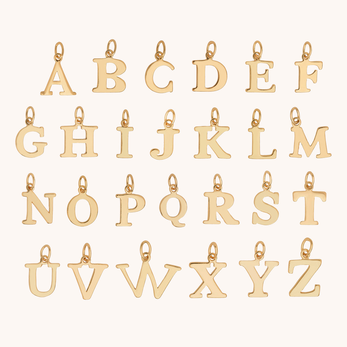 Twenty-six HEX Personalised Birthstone Necklace – Gold Plated charms, each shaped like a capital letter of the alphabet, are arranged in four rows on a light background.