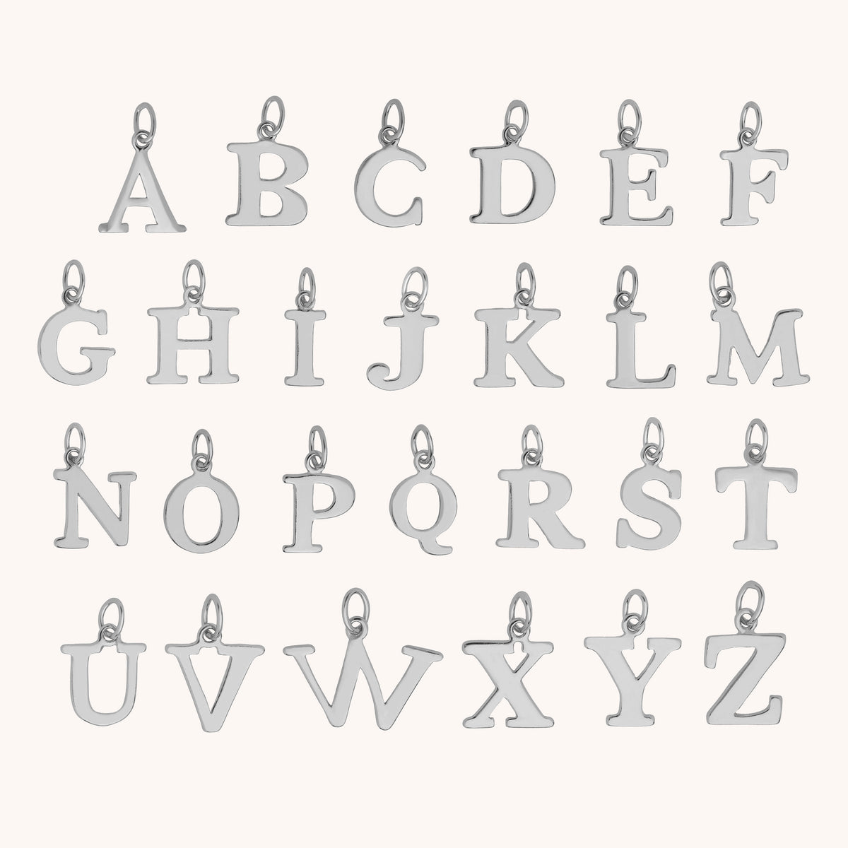 Twenty-six silver alphabet letter charms, from A to Z, each featuring a small loop at the top for easy attachment, are neatly arranged in four rows on a simple, light background—ideal for adding an initial to your HEX Personalised Birthstone Necklace – Sterling Silver or creating a unique piece that’s truly your own.